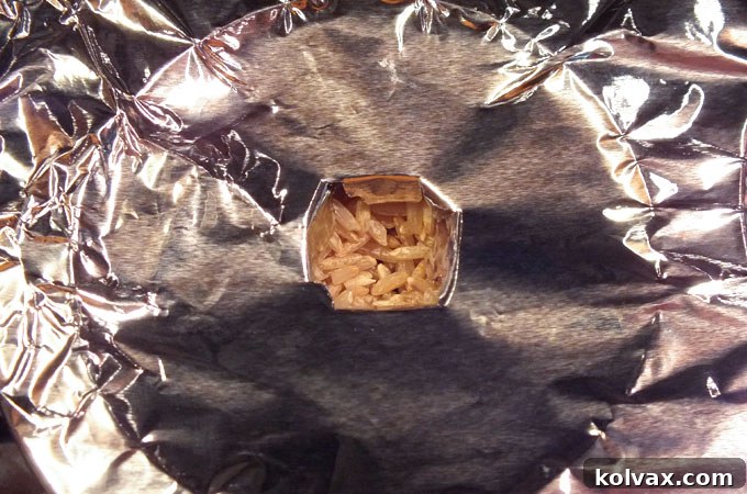 Creating holes in the foil to insert snow cone cups for baking Christmas Tree Cupcakes