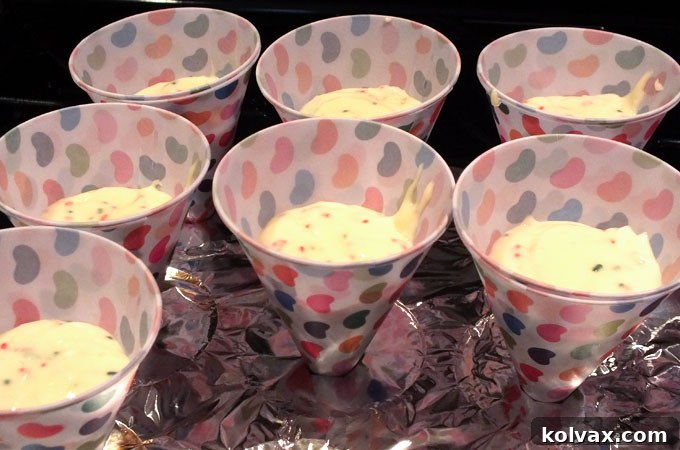 Inserting snow cone cups into the prepared cupcake pan for baking