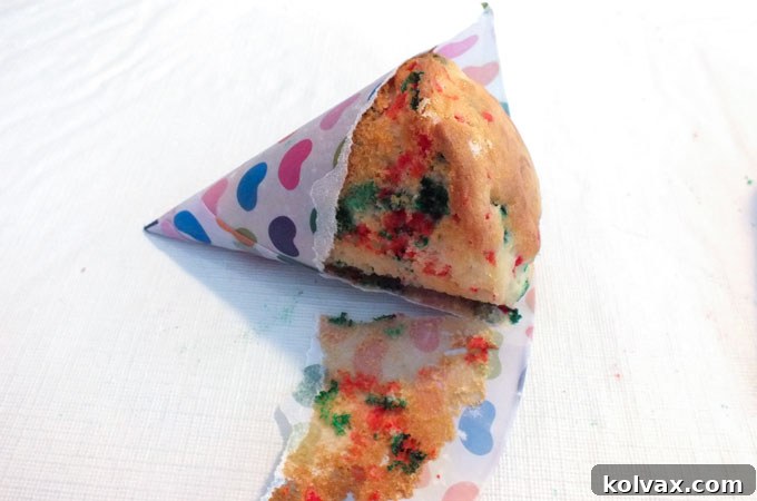 Effortlessly peeling the snow cone cup from the baked Christmas Tree cupcake