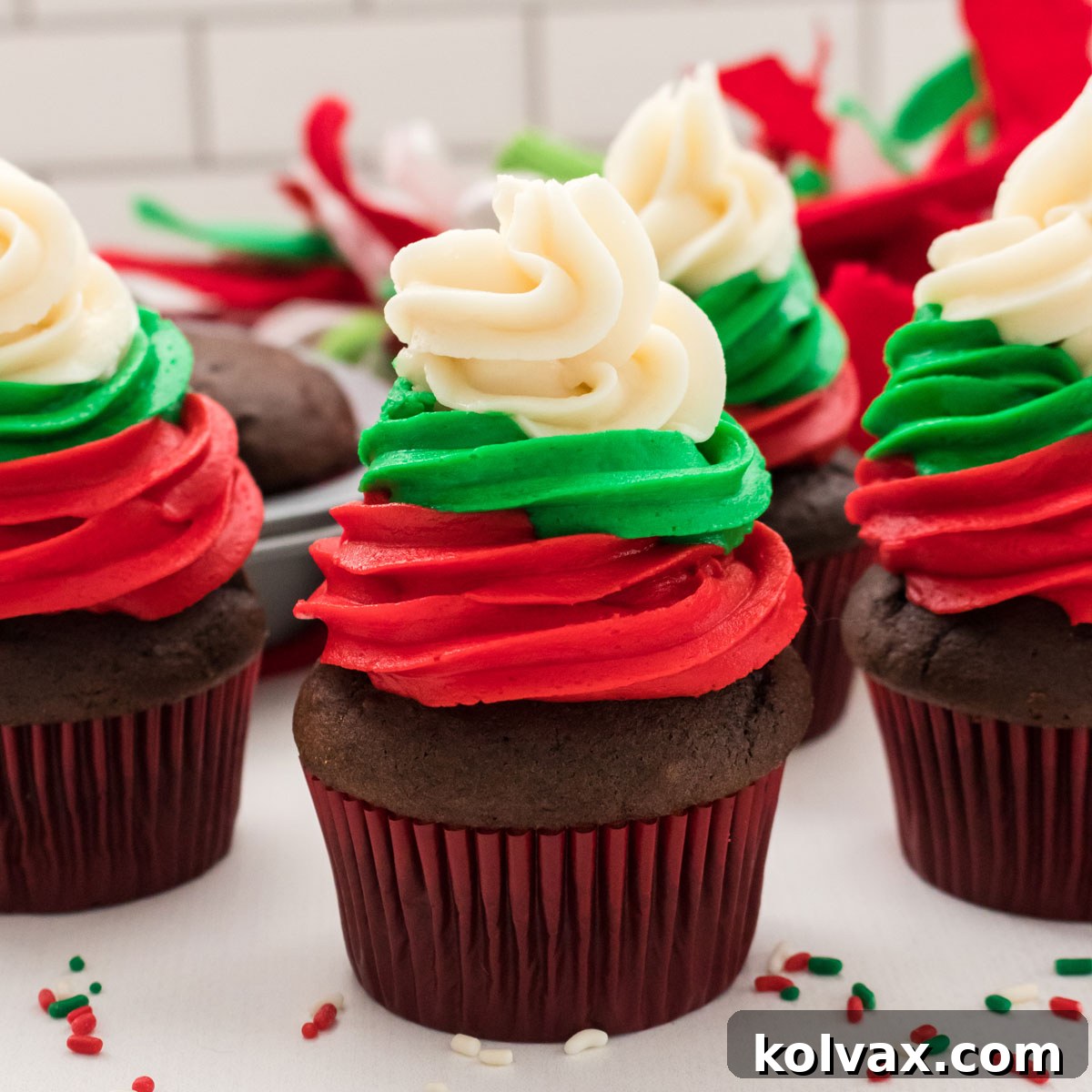Easy Christmas Cupcakes with a festive red, green, and white swirl of buttercream frosting.