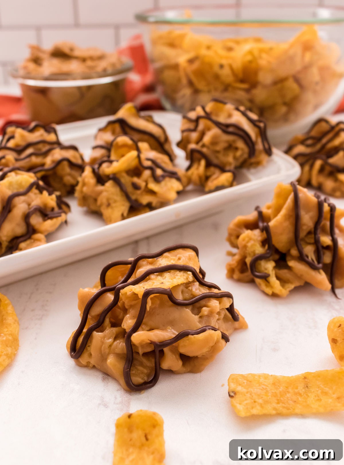 A single Fritos Cookie sits prominently on a white table, with a platter of more cookies and a bowl of Fritos in a soft-focus background, ready to be enjoyed.
