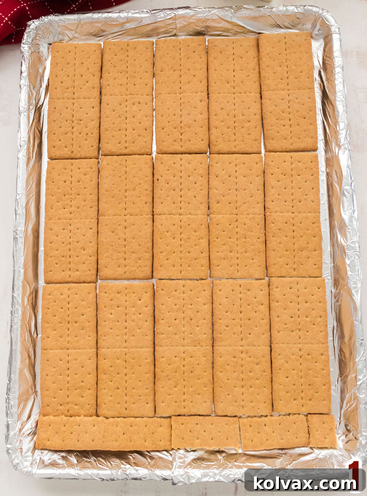 Closeup on a cookie sheet covered in aluminum foil covered with a layer of Graham Crackers.