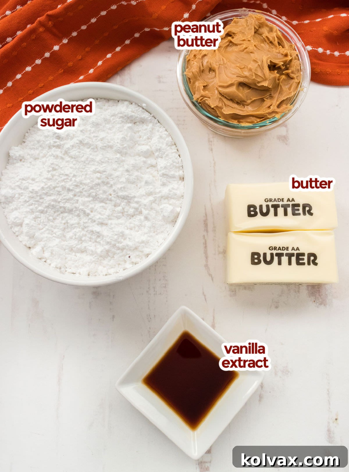 All the core ingredients needed to craft delicious Easy Peanut Butter Fudge, including a block of butter, a jar of creamy peanut butter, a bag of powdered sugar, and a bottle of vanilla extract, neatly arranged.