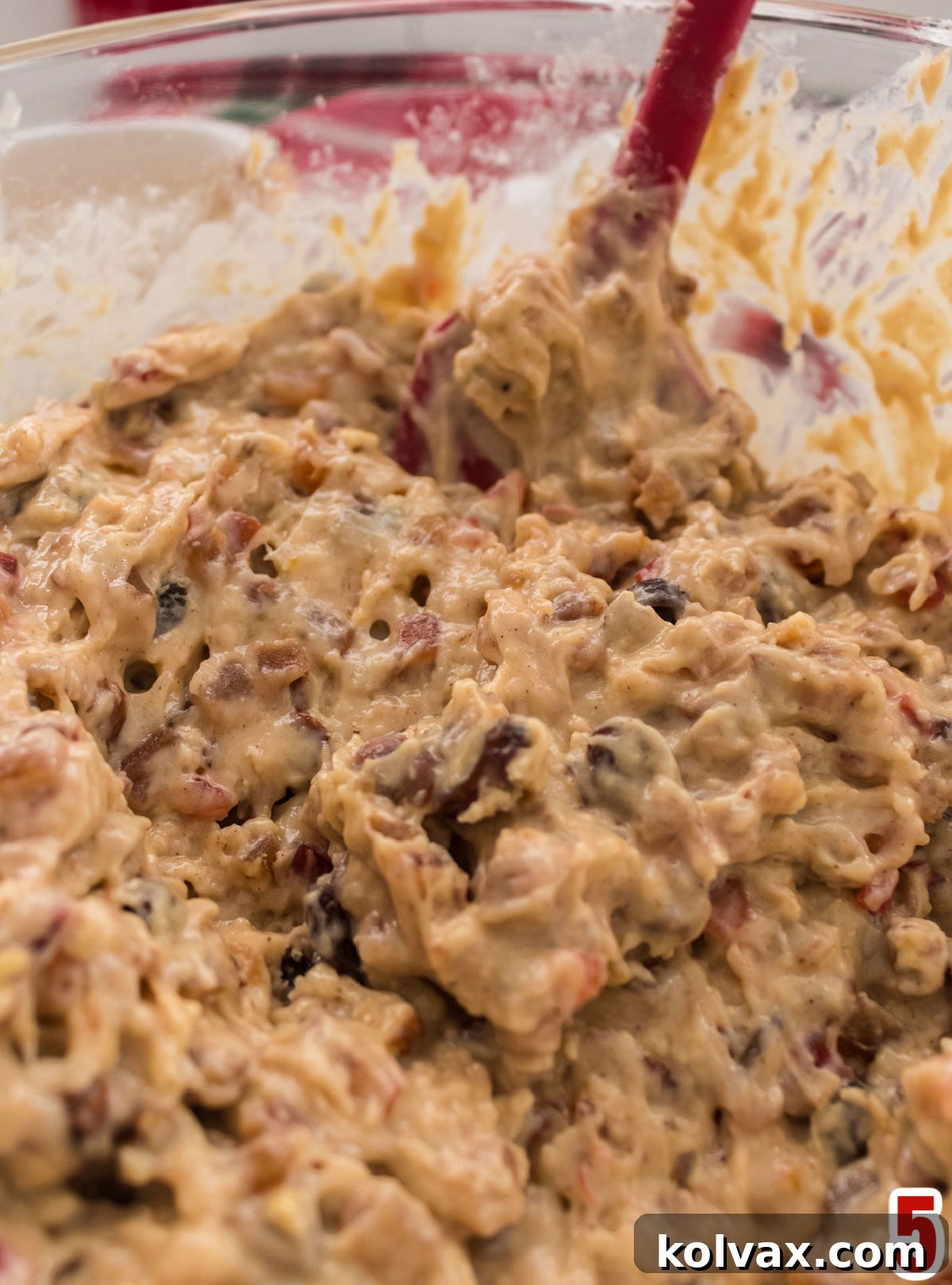 Closeup on a glass mixing bowl filled with the dense and rich Fruit Cake cake batter, ready for baking.