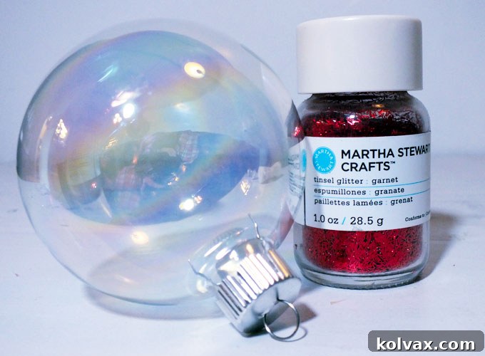 Essential supplies for DIY Red Glitter Christmas Ornaments, including clear glass baubles, red glitter, Mod Podge, a craft brush, and acrylic spray sealer.