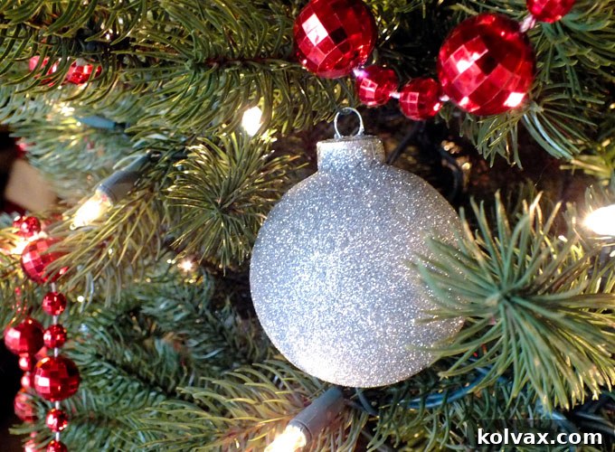 Sparkling Silver Christmas Tree Baubles 7 A close-up of a silver glitter Christmas ornament, highlighting the fine glitter for a subtle and elegant sparkle on the tree.