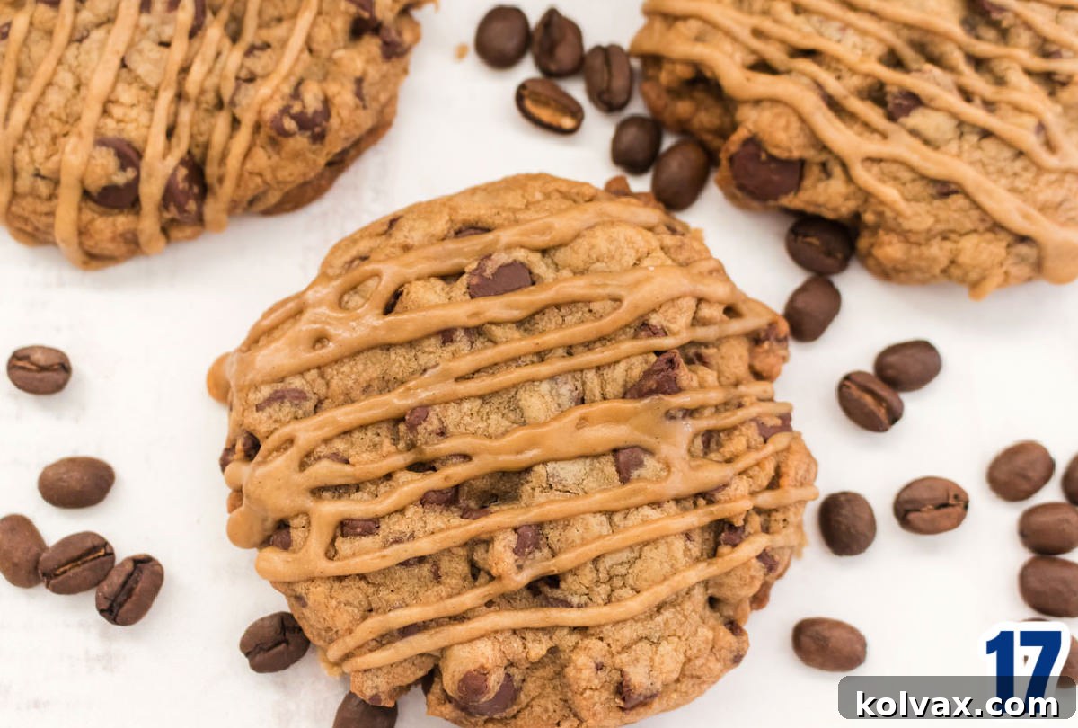 A close-up overhead shot of a single Coffee Chocolate Chip Cookie, perfectly iced and garnished with a few coffee beans, sitting on a pristine white surface, emphasizing its delicious appeal and rich coffee flavor.