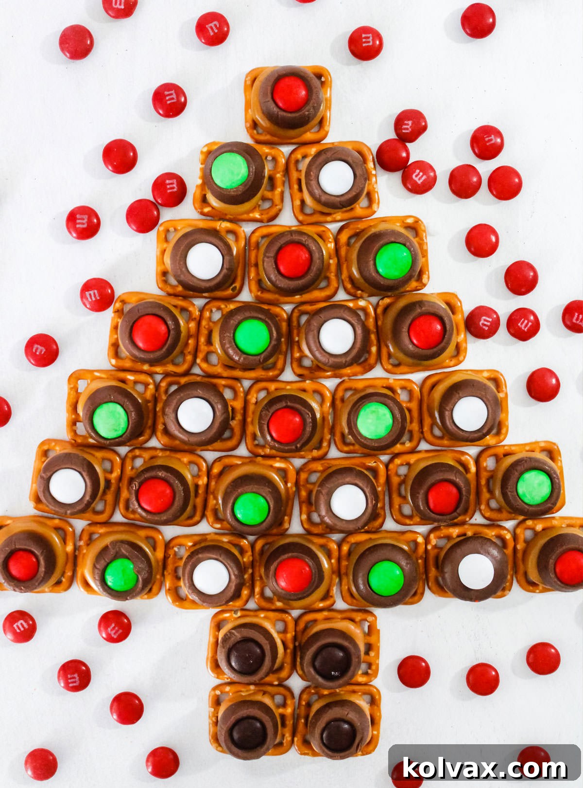 An overhead shot showcasing a beautiful arrangement of Christmas Caramel Pretzel Bites, artfully placed to form the shape of a Christmas tree on a white background.