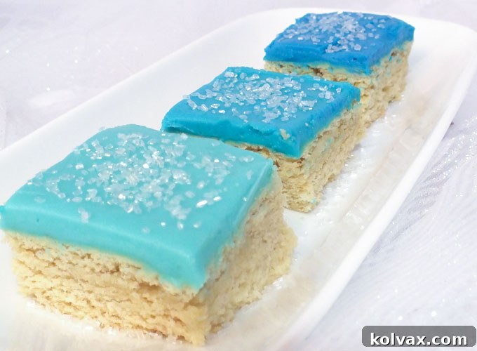 Enchanting Frozen Sugar Cookie Bars with blue frosting and white sprinkles, perfect for a Frozen Birthday Party dessert table. Easy to make and delicious.