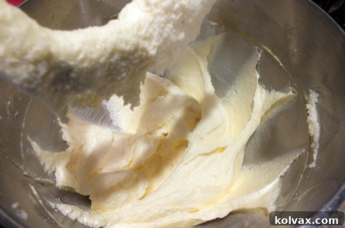 Mixing in eggs and vanilla extract into the creamed butter and sugar mixture for Frozen Sugar Cookie dough.