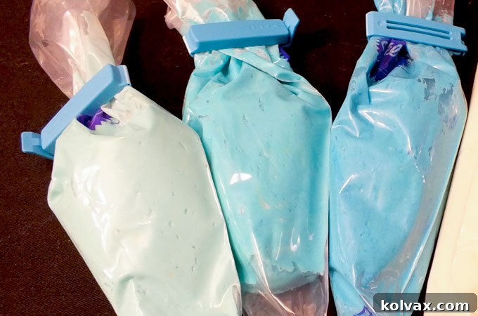 Preparing creamy blue buttercream frosting in three shades for decorating Frozen Sugar Cookie Bars.