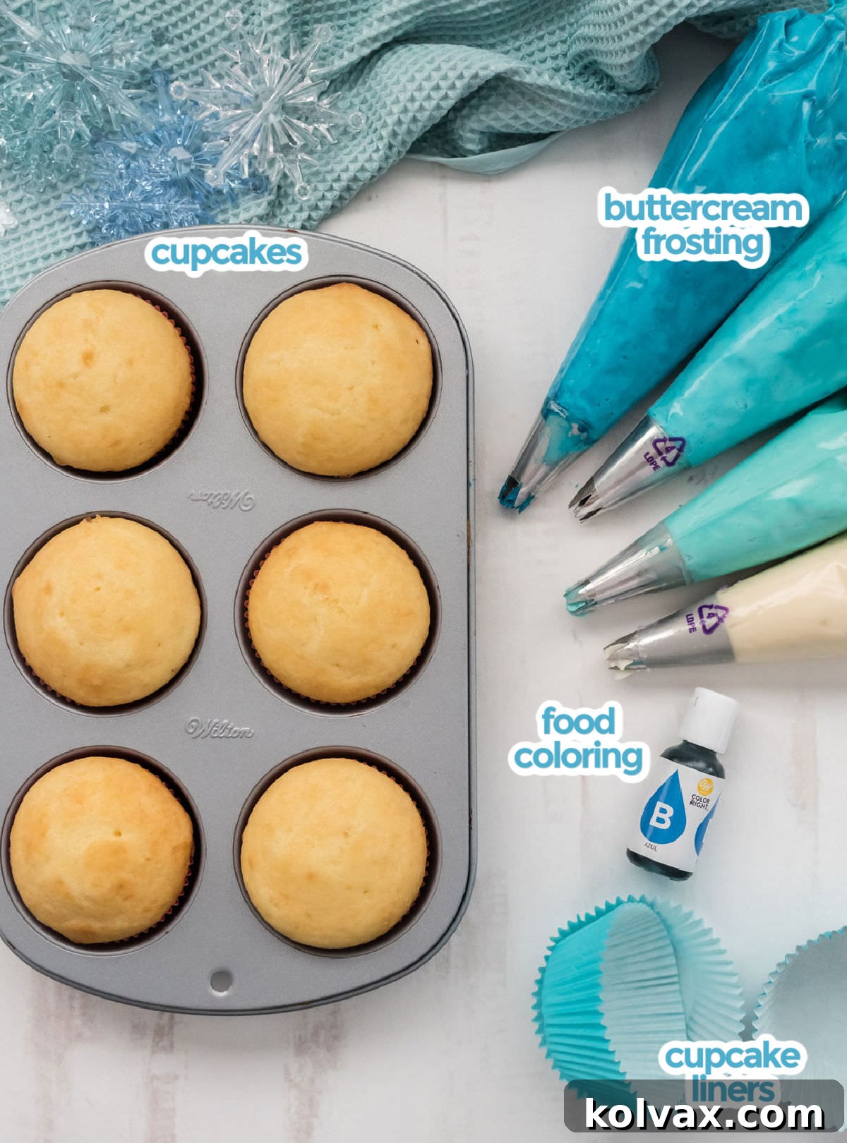Crystalline Gradient Swirl Cupcakes 3 All the ingredients you will need to make Frozen Ombre Swirl Cupcakes including vanilla cupcakes, buttercream frosting, food coloring and cupcake liners, laid out neatly on a white surface.