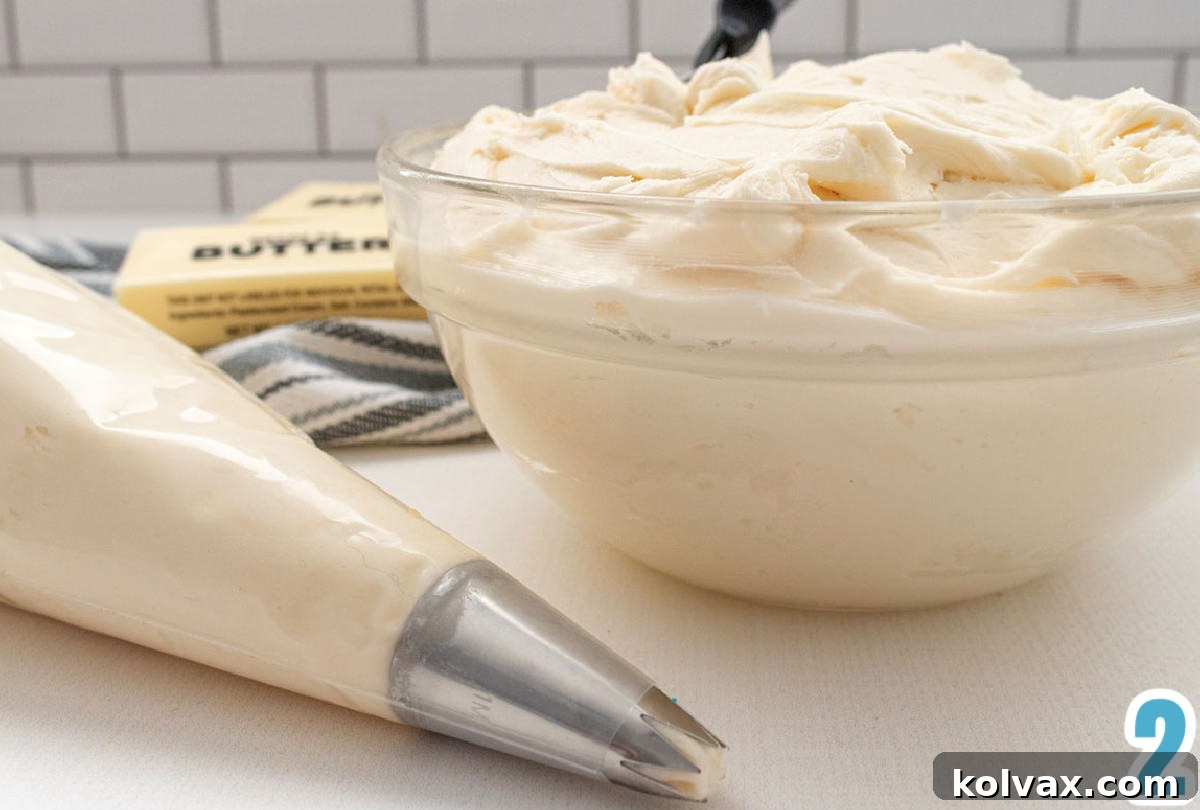 Crystalline Gradient Swirl Cupcakes 5 Closeup on a glass bowl filled with buttercream frosting sitting next to a decorator bag filled with buttercream frosting, ready for coloring and piping.