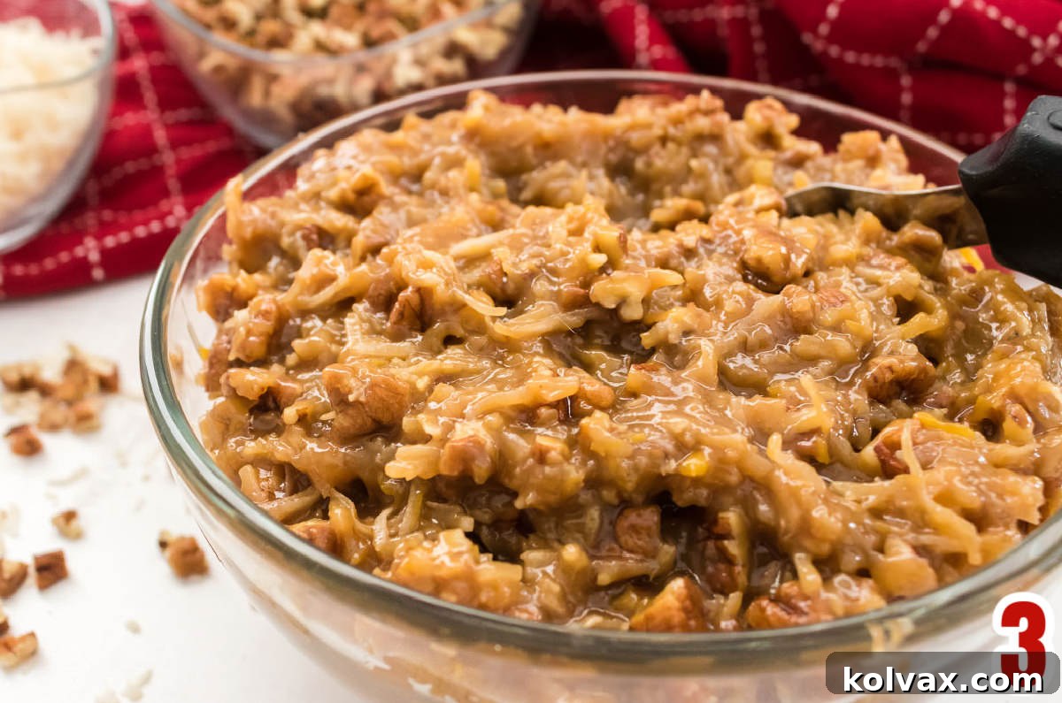 A close-up view of a bowl filled with homemade Coconut Pecan Frosting, highlighting its thick, nutty, and textured consistency.