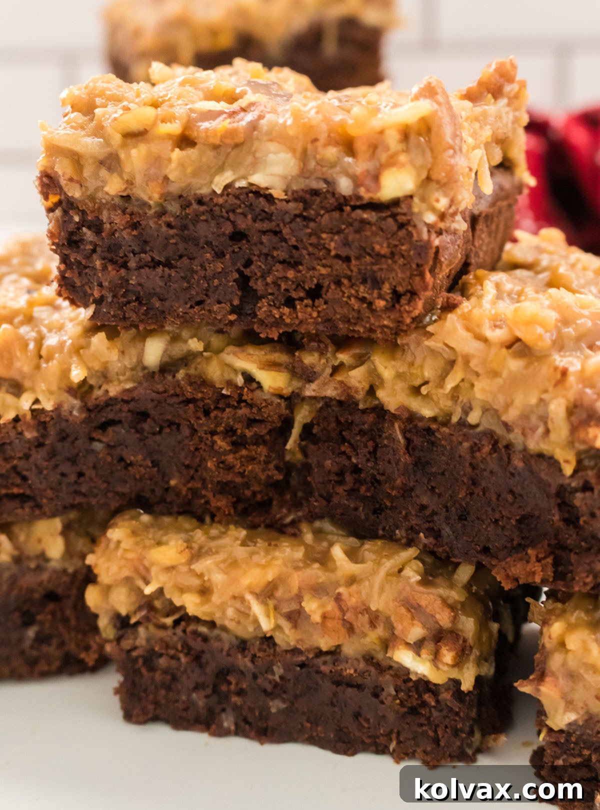 A close-up shot of perfectly stacked German Chocolate Brownies, showcasing the rich texture and delicious frosting, ready to be enjoyed.