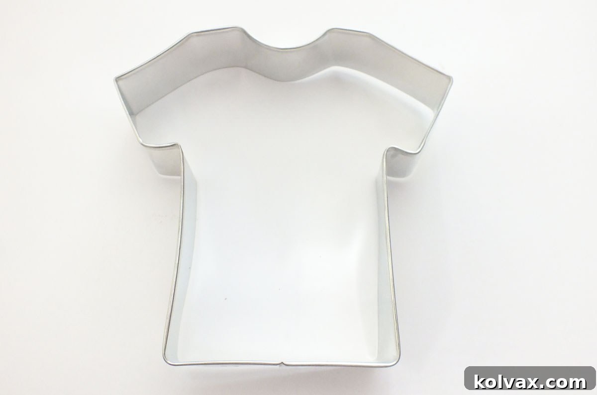 Overhead shot of a T-Shirt shaped Cookie Cutter laying on a white table.