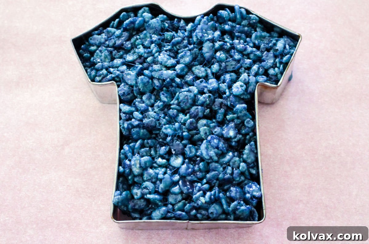Closeup on the Shirt Cookie Cutter filled with blue Rice Krispie Treat mixture.