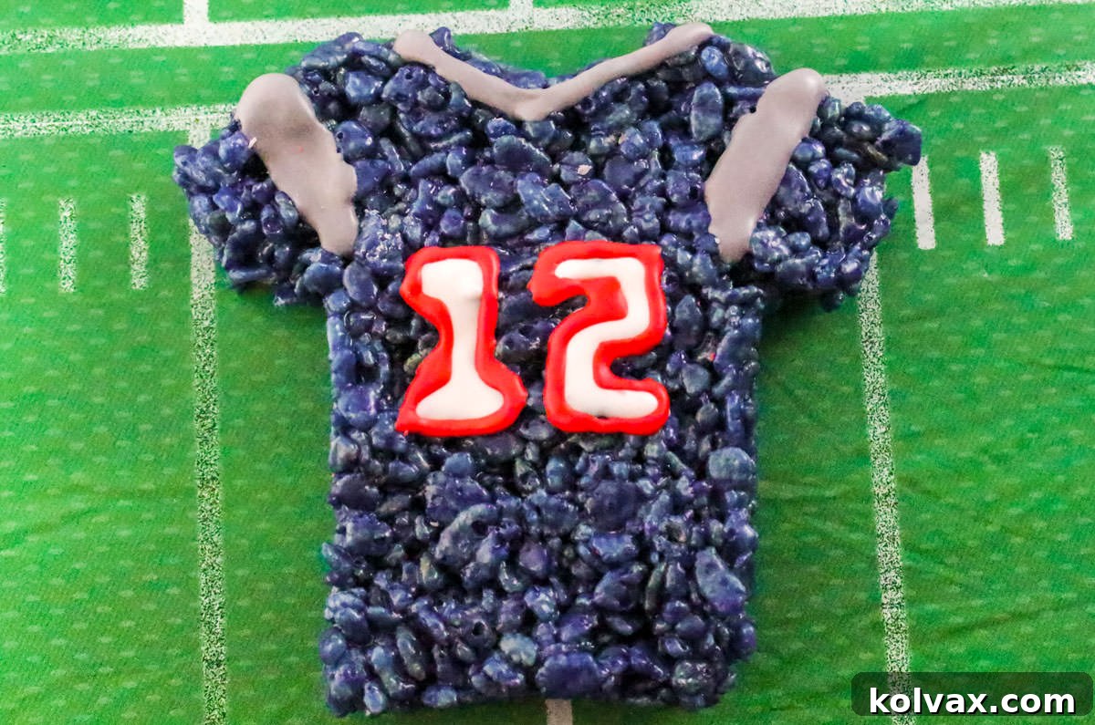 Closeup on a single New England Patriots Rice Krispie Treat laying on a table covered with a football table cloth.