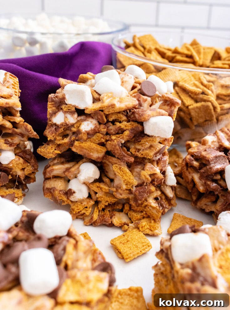 Golden Grahams S'mores Marshmallow Treats stacked on a white plate, ready to be enjoyed.