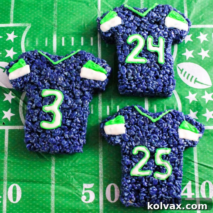 A close-up shot of three beautifully decorated Seattle Seahawks Rice Krispie Treat Jerseys laid out on a festive football-themed tablecloth, ready for game day.