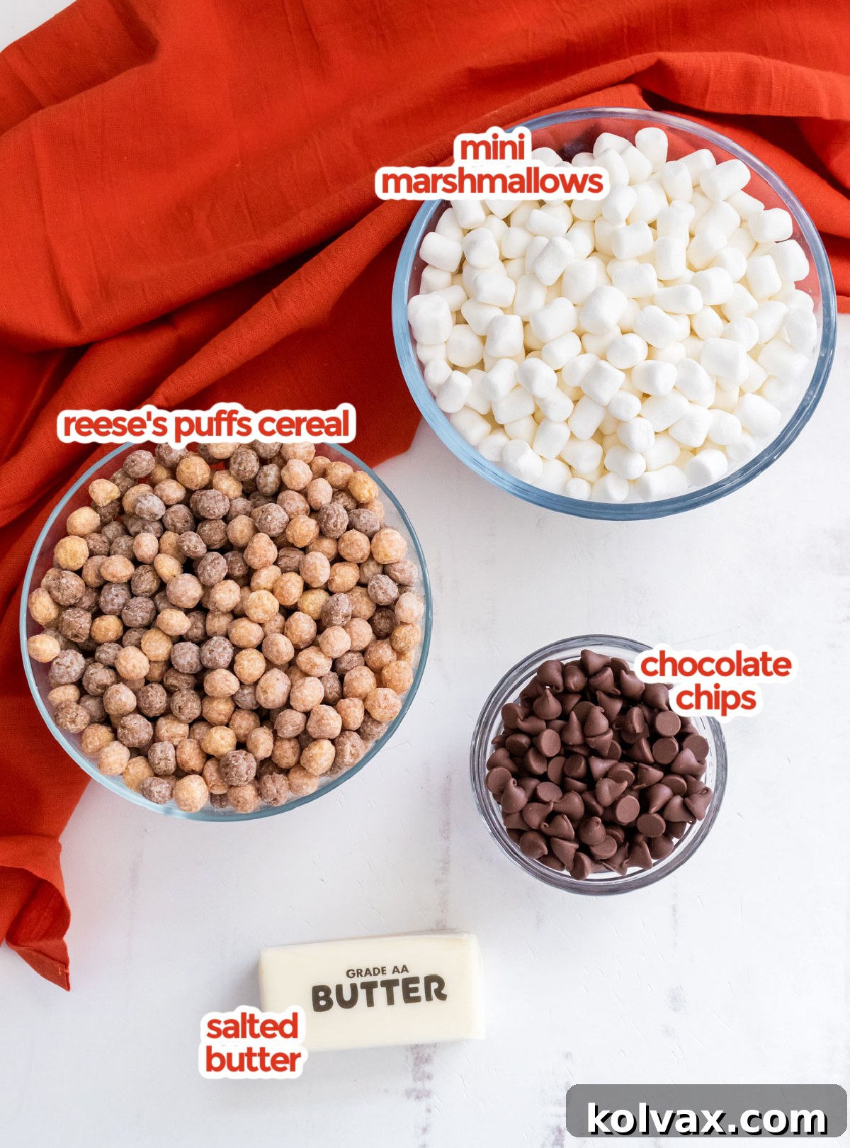 All the essential ingredients neatly arranged for making Reese's Puffs Marshmallow Treats, including butter, marshmallows, Reese's Puffs cereal, and chocolate chips.