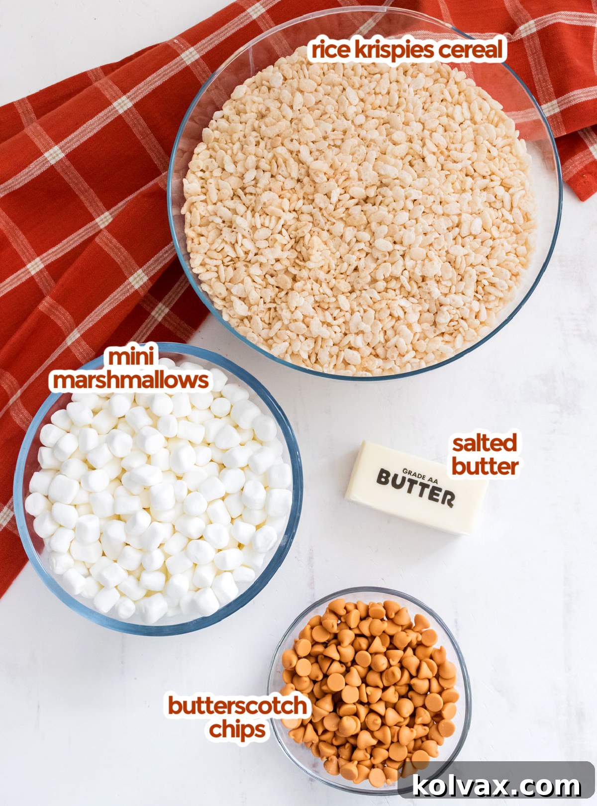 All the essential ingredients neatly laid out to make the perfect batch of Butterscotch Rice Krispie Treats: butter, mini marshmallows, butterscotch chips, and Rice Krispies cereal.