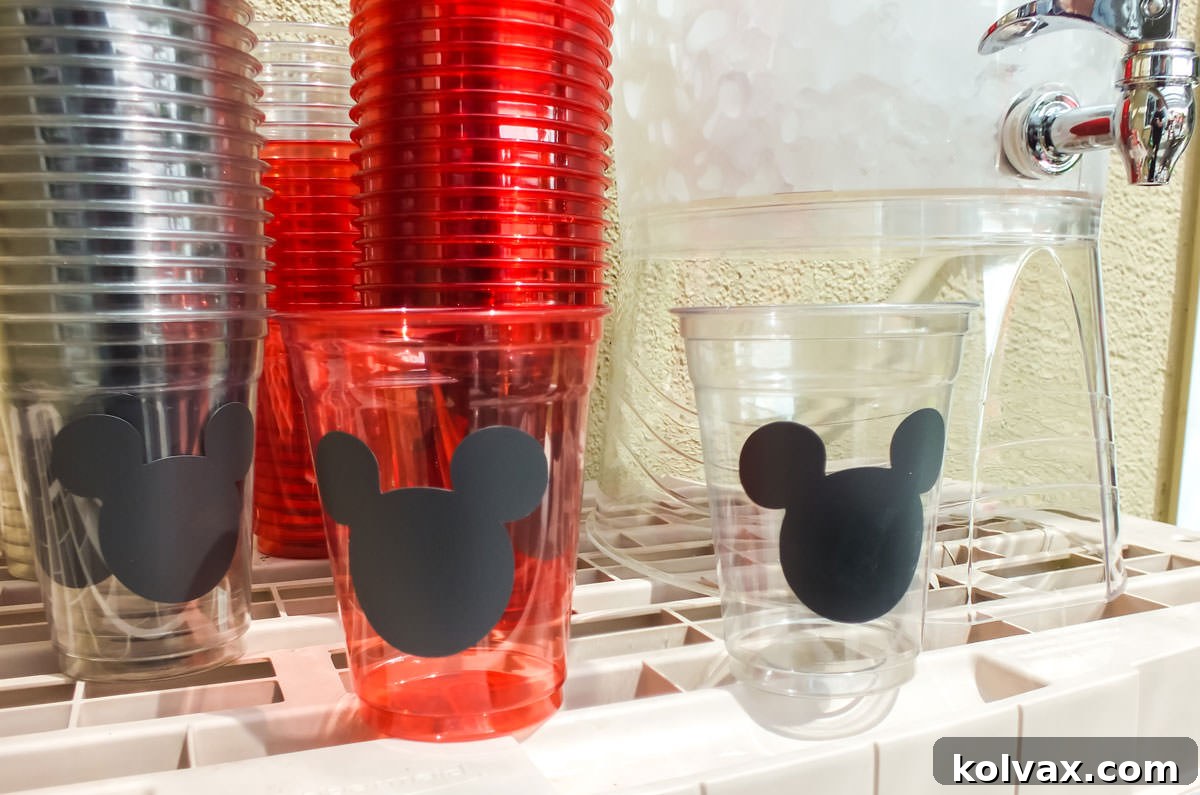 Red and white plastic cups decorated with chalkboard vinyl Mickey Mouse heads for a party.