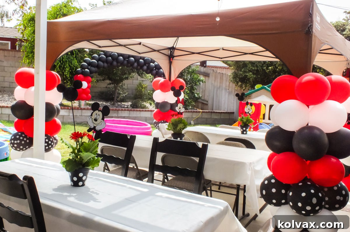 Red, black, and white balloon columns decorating a Mickey Mouse themed party entrance.
