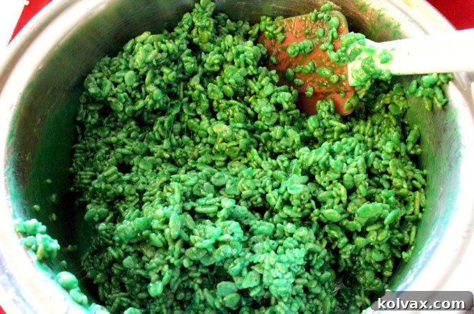 Molding green Rice Krispie Treat mixture into a football jersey cookie cutter