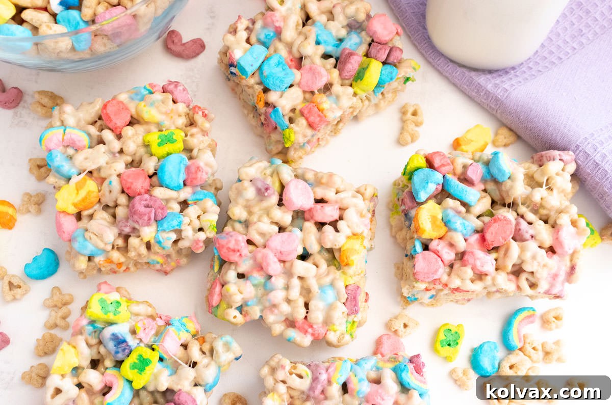 Charmed Marshmallow Delights 7 Overhead shot of a batch of Lucky Charms Marshmallow Treats sitting on a white table with a lilac kitchen towel.