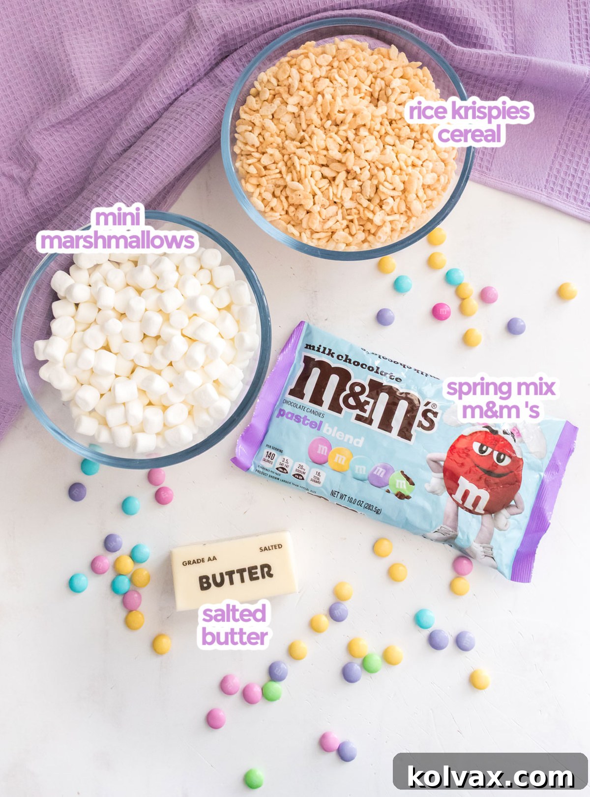 A beautifully arranged selection of all the ingredients needed to craft delicious Springtime M&M Rice Krispie Treats, including butter, marshmallows, cereal, and pastel M&M's.