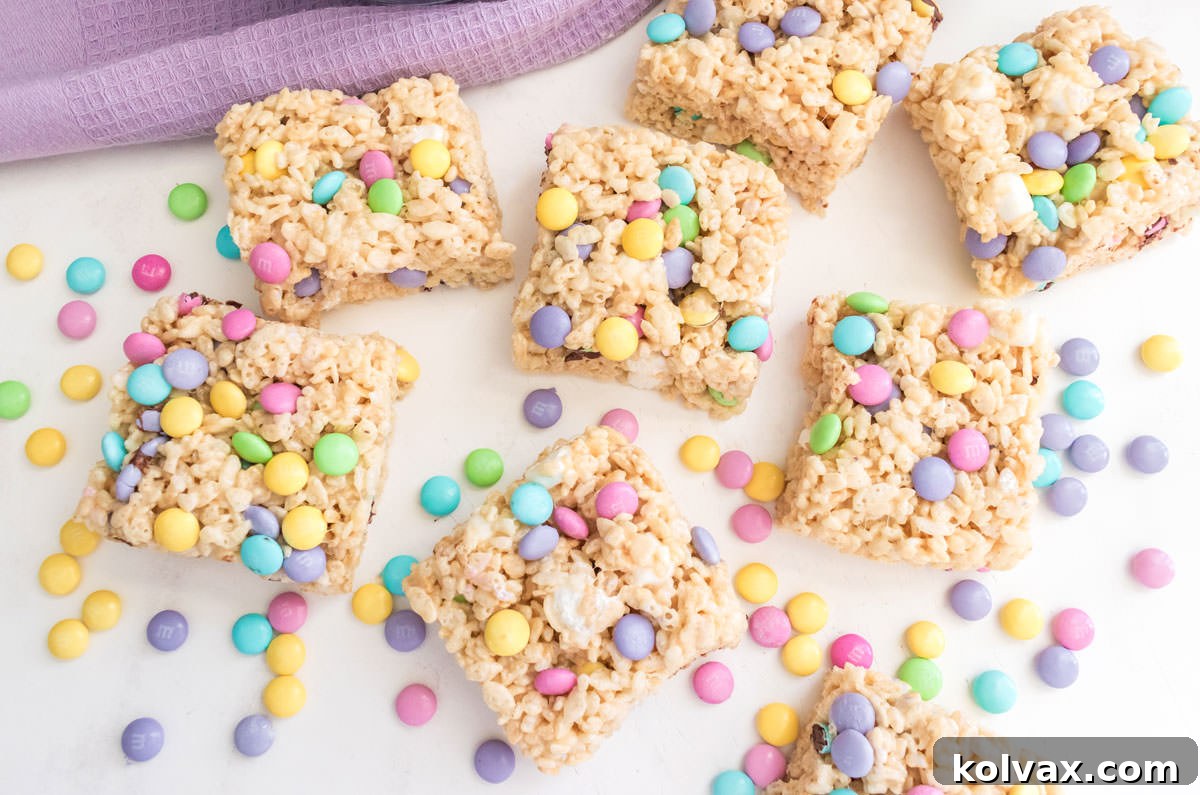 An overhead shot showcasing a delightful batch of freshly made Springtime M&M Rice Krispie Treats laid out on a clean white table, ready to be enjoyed.