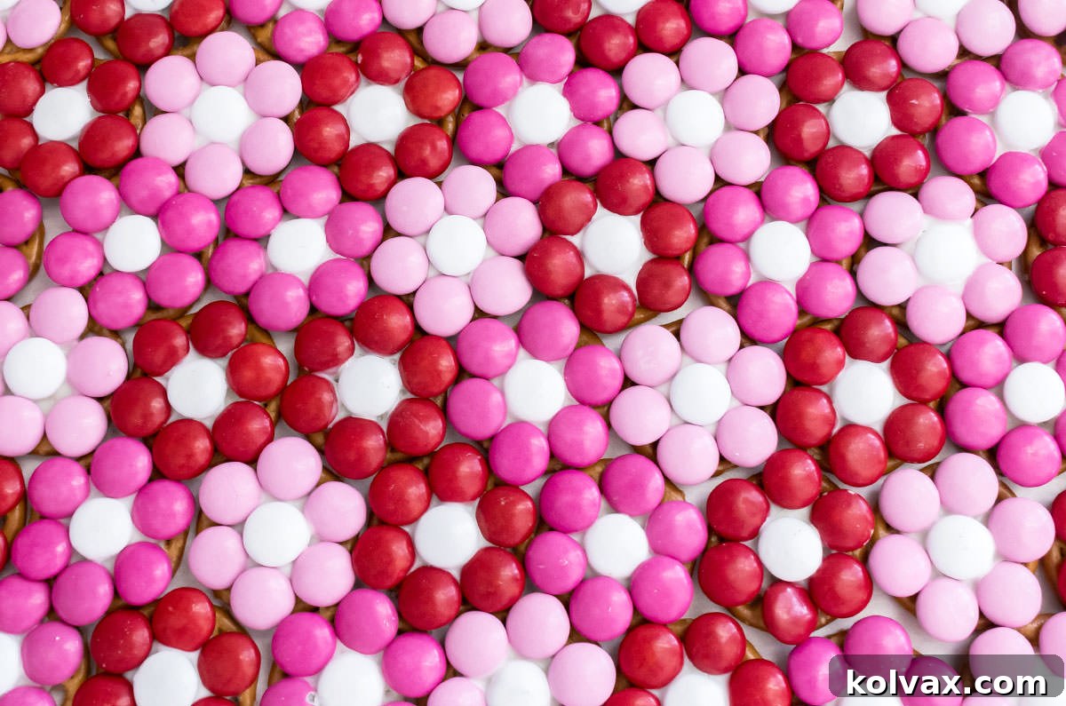 A generous batch of Rose Garden Flower Pretzel Bites neatly arranged in rows on a clean white surface, highlighting their abundant charm and readiness for storage or serving.