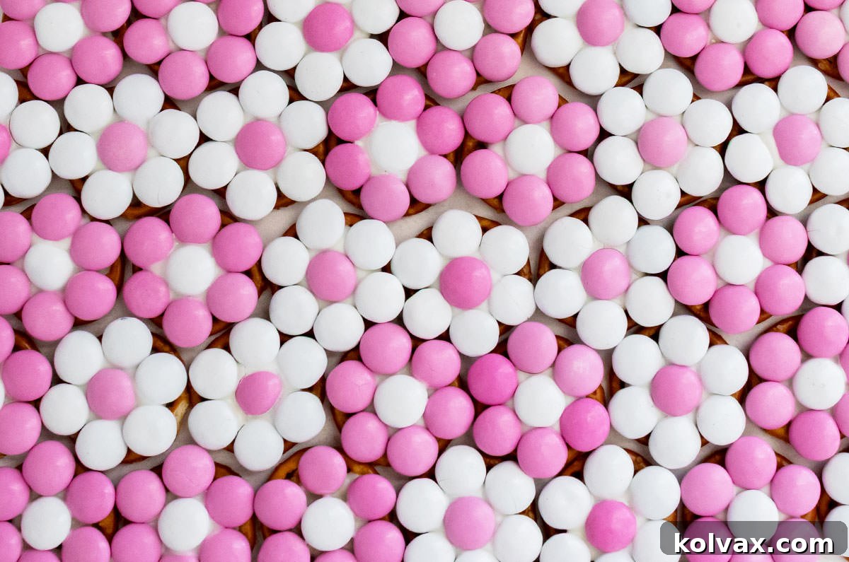 An overhead view of neatly arranged rows of Pretty in Pink Flower Pretzel Bites, showcasing their uniformity and vibrant colors.