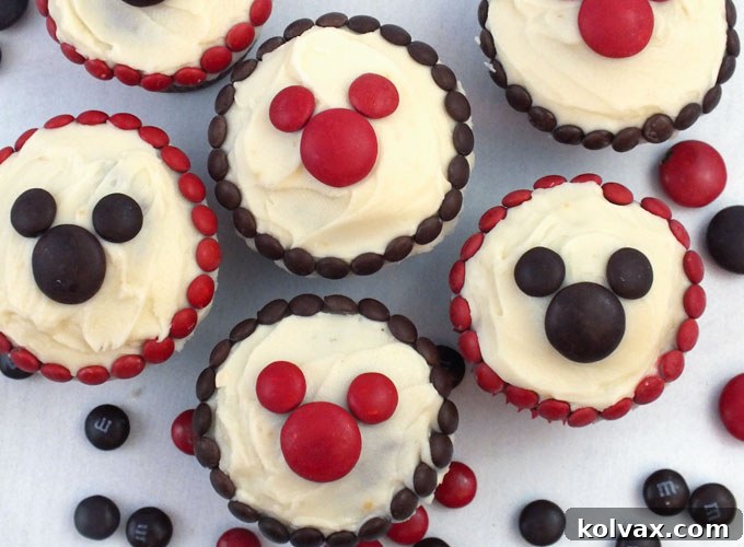 M&M Mickey Cupcakes - so adorable and so easy to make! A great dessert for a Mickey Mouse Party, a fun baking activity to do with your kids or a nice treat for that Disney Fan in your life. Follow us for more fun Mickey Mouse Party Ideas.
