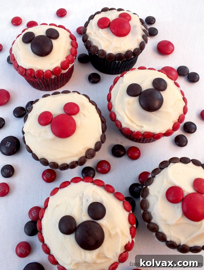 M&M Mickey Cupcakes - so adorable and so easy to make! A great dessert for a Mickey Mouse Party, a fun baking activity to do with your kids or a nice treat for that Disney Fan in your life. Follow us for more fun Mickey Mouse Party Ideas.