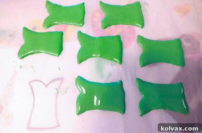 Creating a Tinkerbell dress template with royal icing on parchment paper.