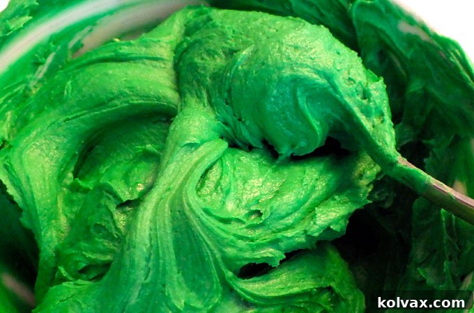 Vibrant green buttercream frosting in a bowl, ready for piping.