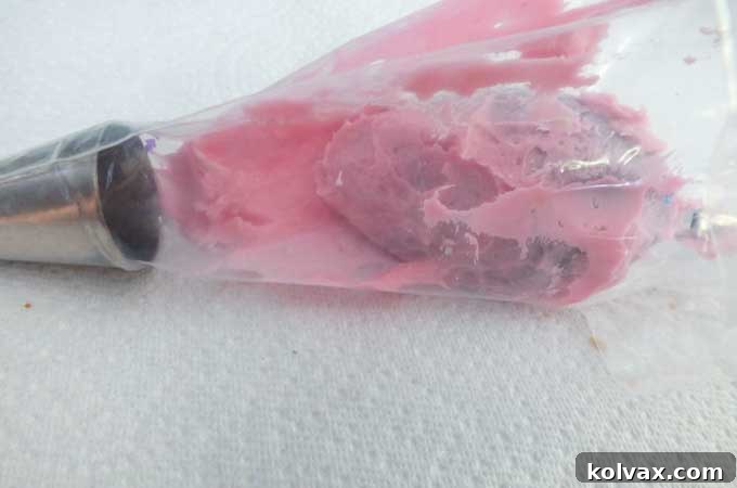 Whimsical Hydrangea Sugar Cookies 6 Step-by-step guide: Spooning pink frosting along the inside wall of a pastry bag