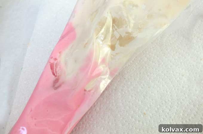 Whimsical Hydrangea Sugar Cookies 8 Filling the center of the pastry bag with ivory frosting, after lining the sides with pink