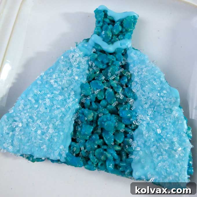 Our Elsa Dress Rice Krispie Treats are a delicious and easy to make Frozen Dessert decorated to represent Queen Elsa's famous Ice Queen Dress. They are perfect for a Frozen Birthday Party and we have all the step by step directions you'll need to make these for your Frozen Party. Follow us for more fun Frozen Party Ideas.