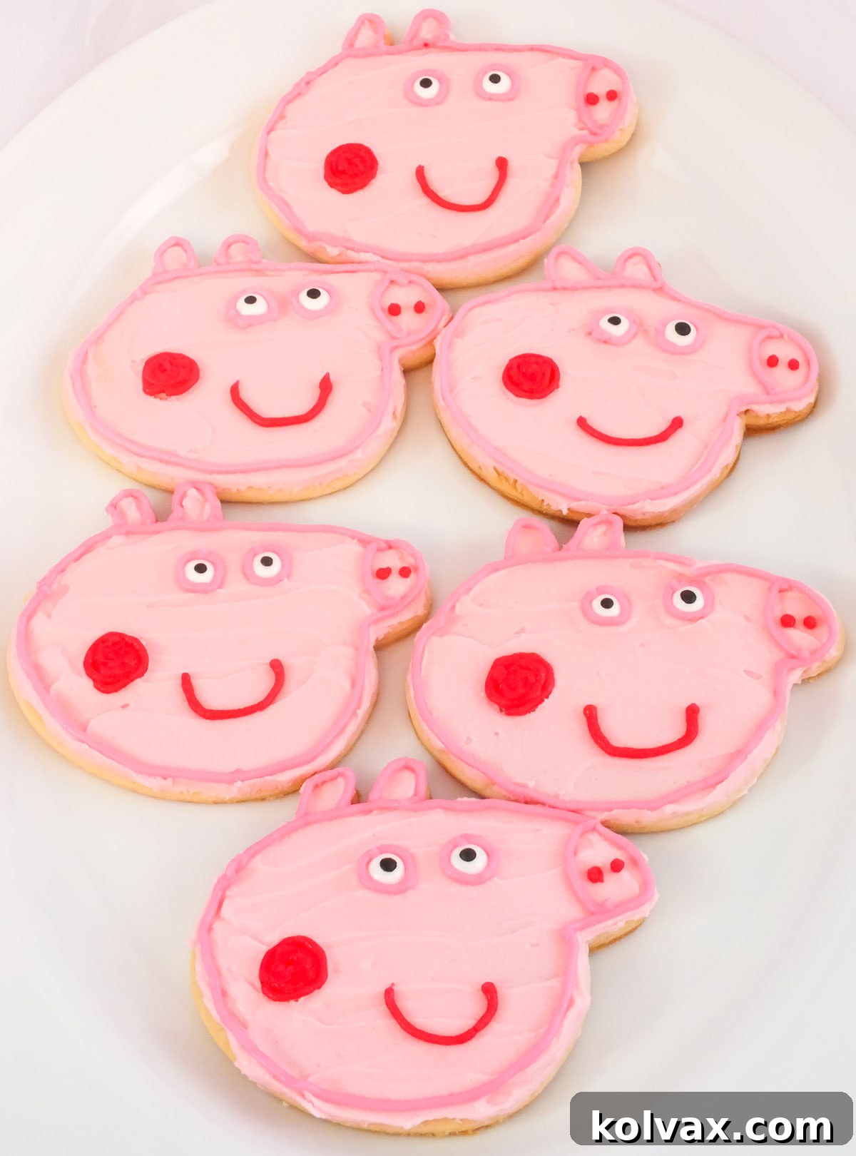 White elegant serving platter thoughtfully filled with six perfectly decorated Peppa Pig Cookies, arranged beautifully for guests to enjoy.