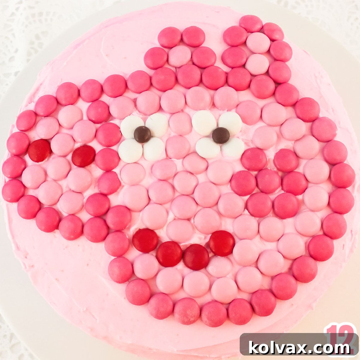 Closeup on the top of a Peppa Pig Cake showing the Peppa face made out of Pink M&M's.
