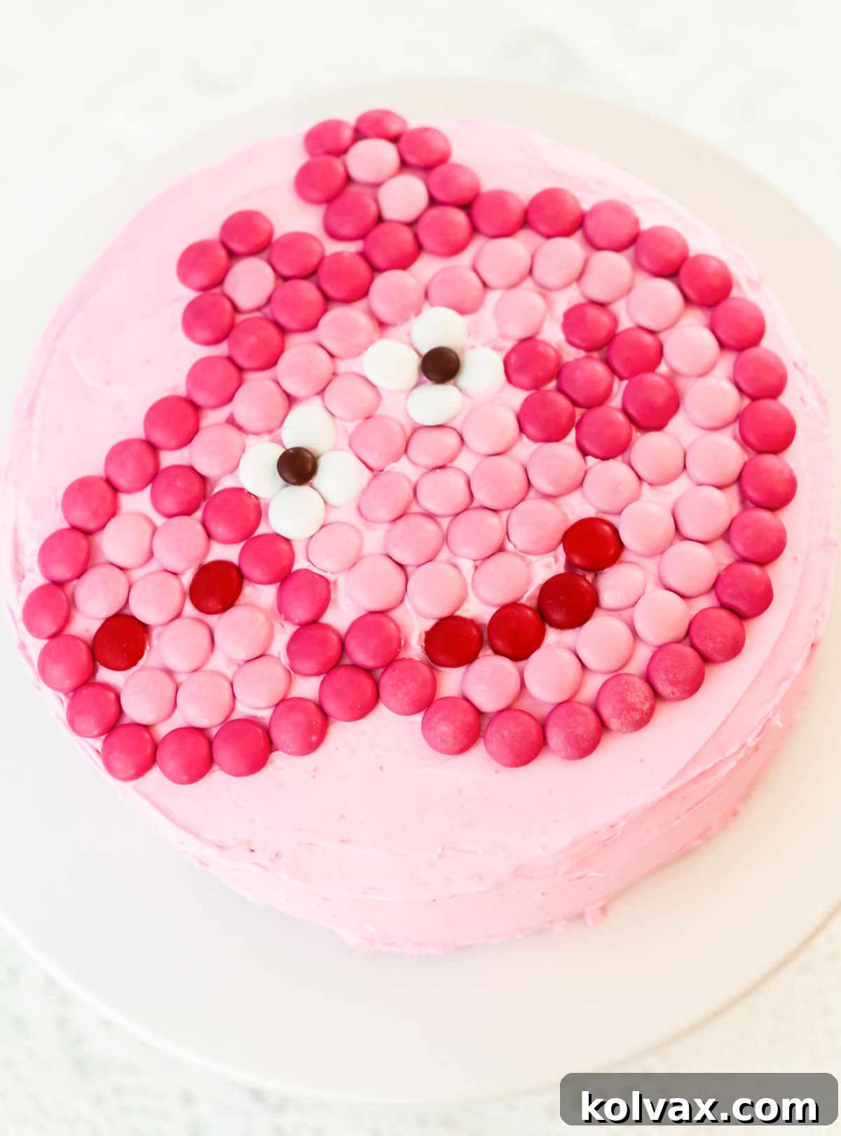Closeup of an Easy Peppa Pig Cake sitting on a white cake plate on a white table.