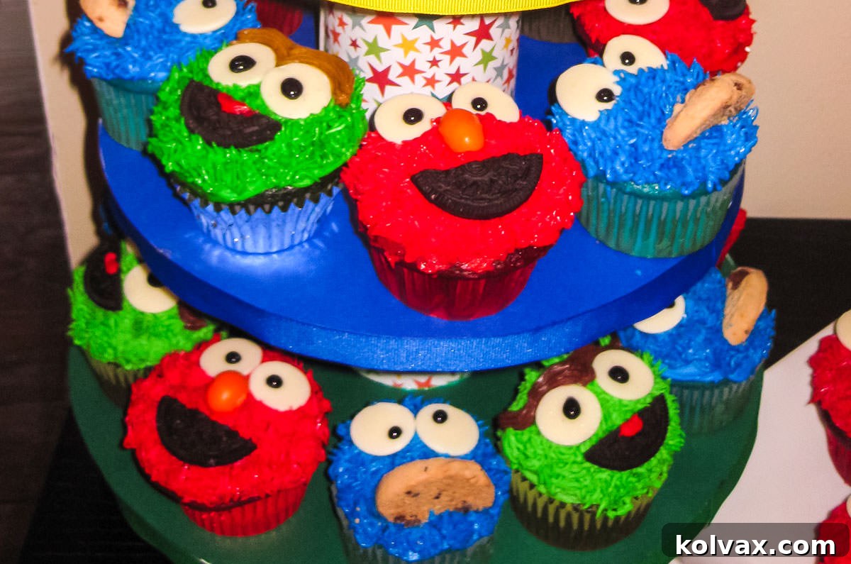 Closeup on two rows of a Cupcake Stand filled with Sesame Street Cupcakes including Elmo Cupcakes, Cookie Monster Cupcakes and Oscar the Grouch Cupcakes, showcasing vibrant character details.