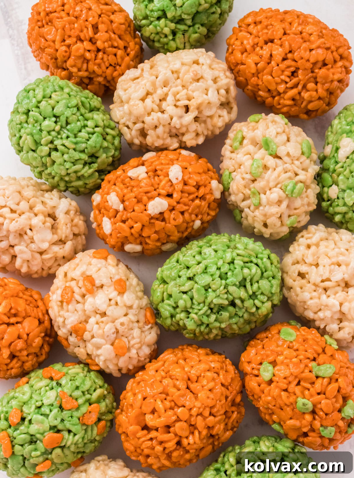 Closeup of 18 Dinosaur Eggs Rice Krispie Treats laying on a white surface.