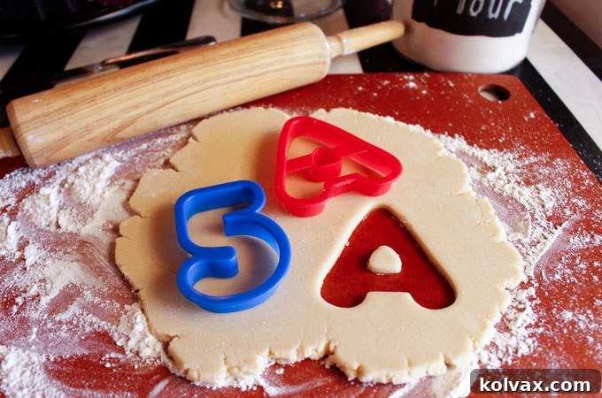 Ingredients and baked sugar cookies for Dinosaur Party Thank You Cookies, featuring letter 'A' and number '5' shapes.