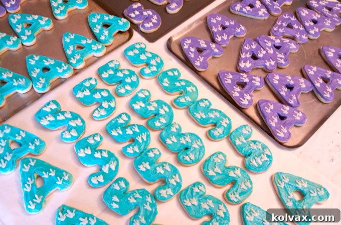 A large collection of freshly decorated Dinosaur Party Thank You Cookies, ready for packaging.