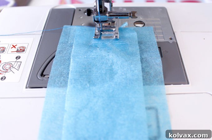 Make Stunning Ruffled Streamers 4 Sewing ruffled streamers on a sewing machine, demonstrating how to align three strips of crepe paper for gathering, with the needle positioned to create a central seam.