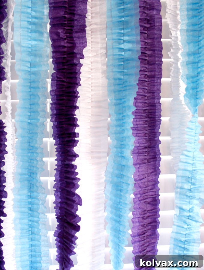 Make Stunning Ruffled Streamers 7 A close-up view of beautifully crafted ruffled streamers in white, blue, and purple, highlighting the texture and volume created. These easy and inexpensive party decorations are ideal for adding a festive touch to any birthday, baby shower, or holiday party.